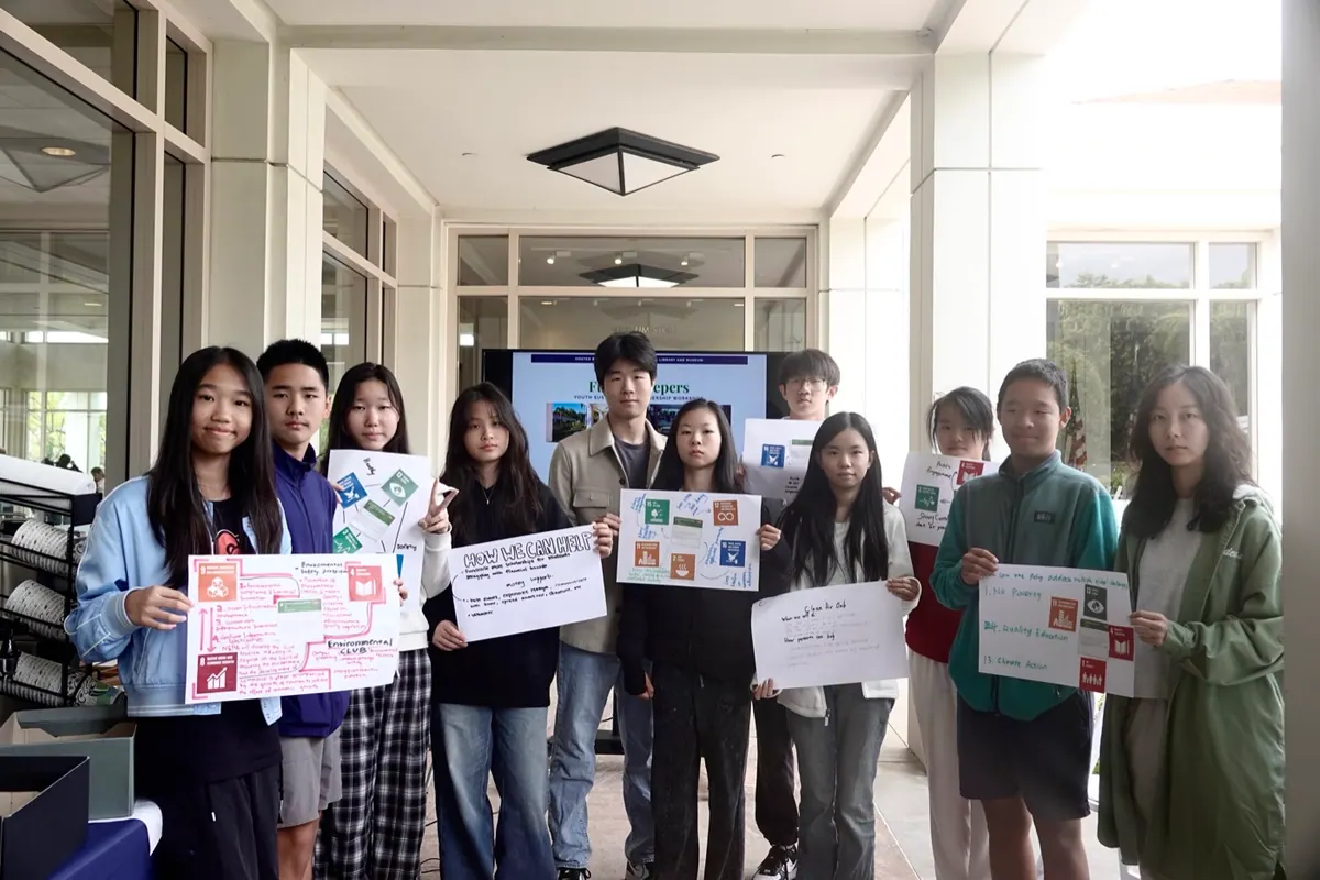 Future Keepers youth participants with their SDG-themed family action posters at the Nixon Presidential Library entrance