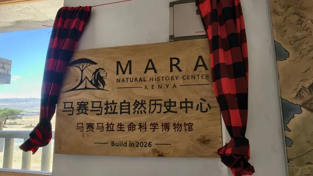 The plaque of the Mara Natural History Center, draped in a red Maasai shuka for the opening